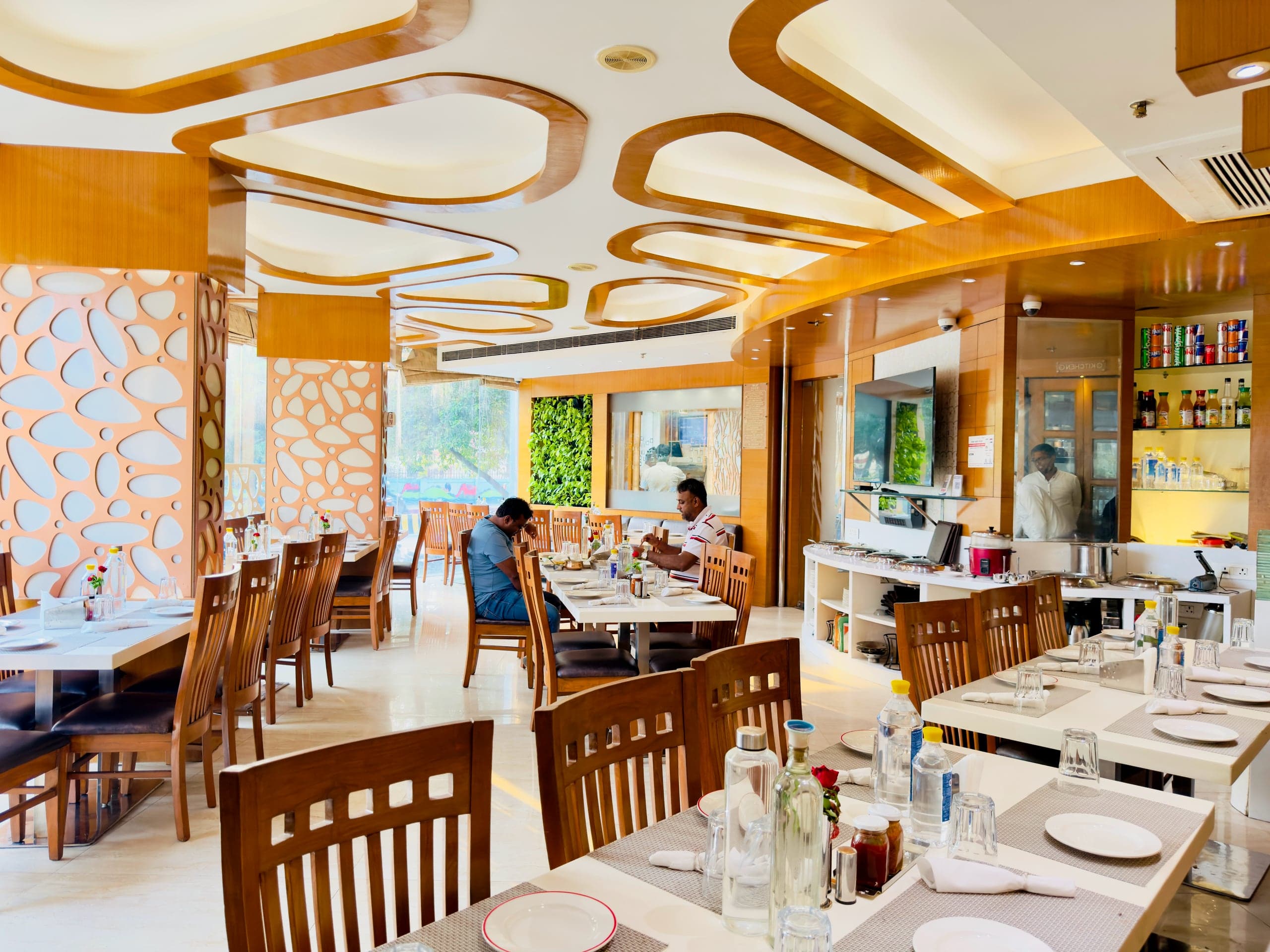 The full dining room at Flavours — daylight from the street windows, staff at the counter