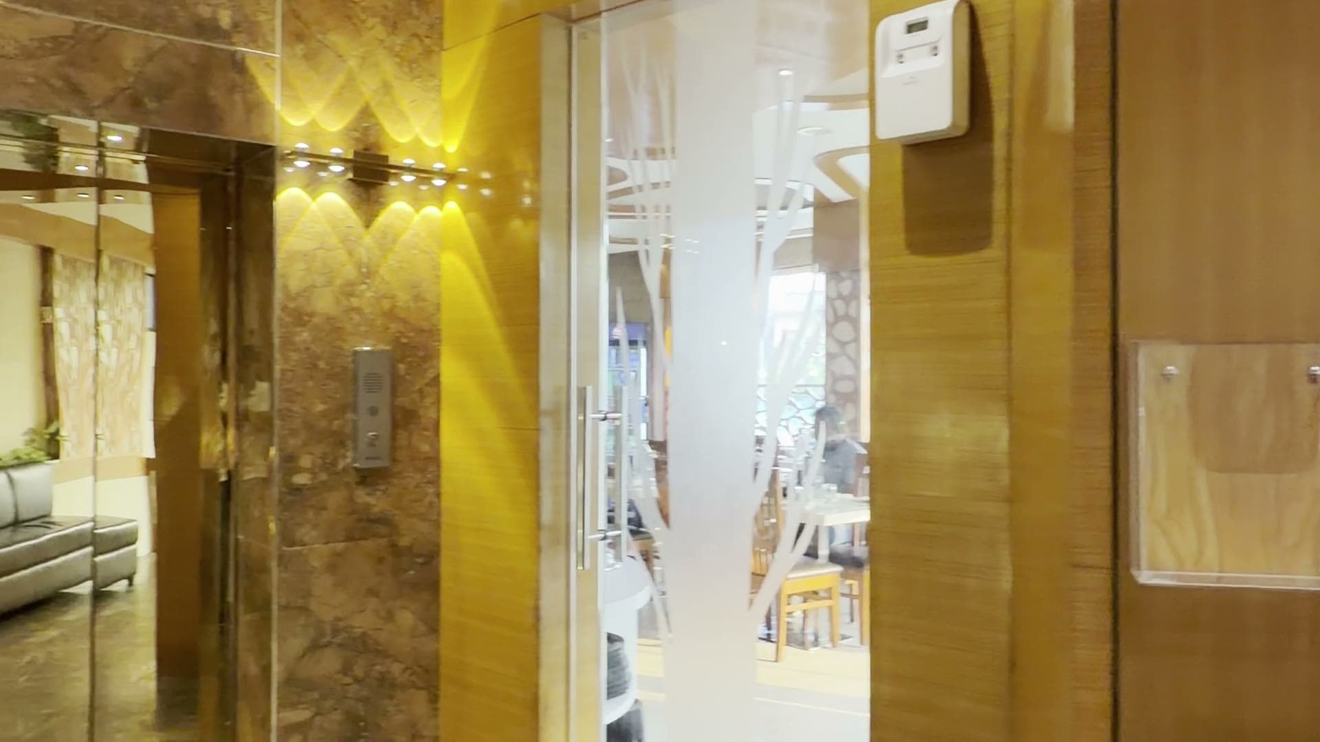 The lobby of Hotel Vagmi, Varanasi — frosted glass doors and a golden jaali screen