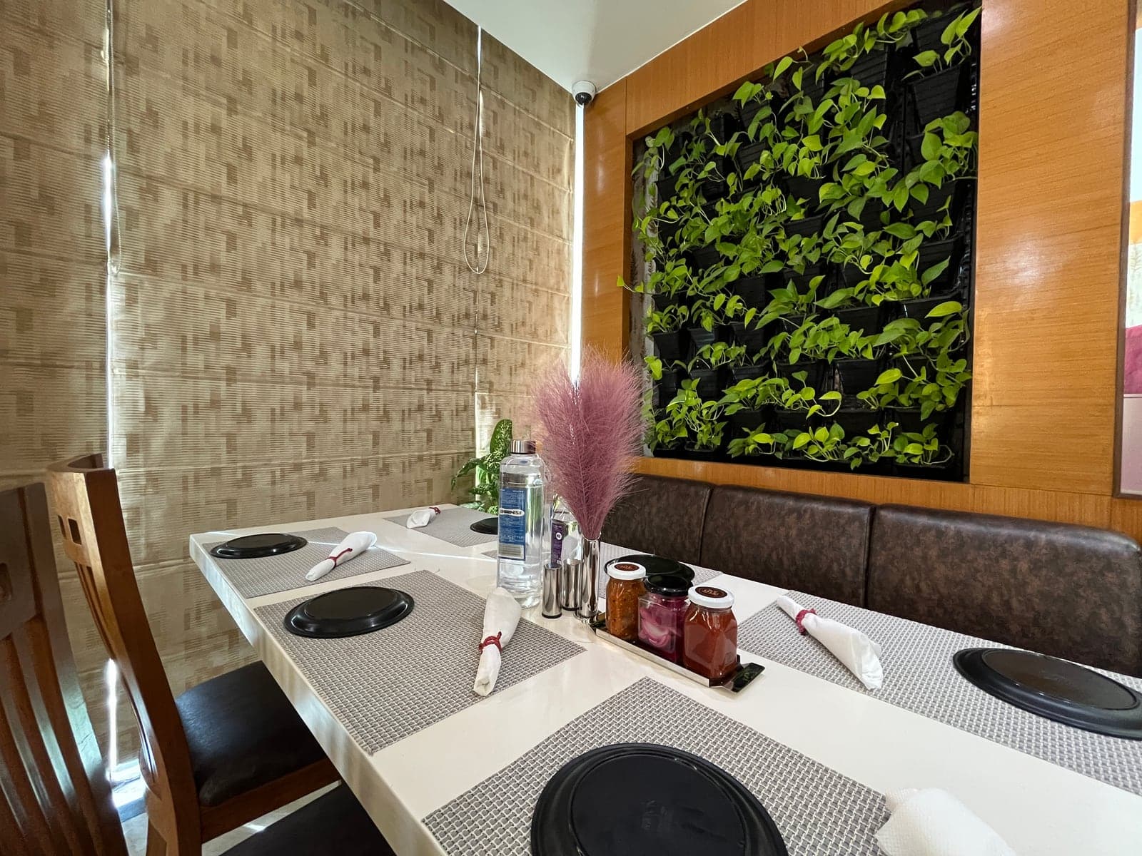 A laid table at Flavours against the living green wall